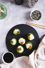Canvas Print - Vegetarian sushi rice, carrots and green onions wrapped in cucumber top and vertical view
