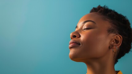 A profile side view of a woman against a blue background, with her face mysteriously blurred out