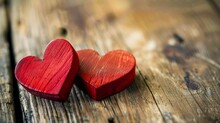 Two Red Wooden Hearts On A Wooden Table.