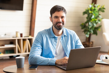Aufkleber - A man entrepreneur is seated at a table, engrossed in his laptop. He appears focused and concentrated on his work or task at hand.