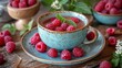 Glass Cup of Raspberries Next to Plate of Raspberries