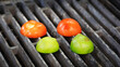 Three tomatoes and two limes are on a grill