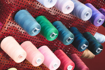 Aufkleber - A rack of colorful spools of thread. The spools are of various colors and sizes. The spools are arranged in a way that they are easily accessible and visible. Concept of organization and variety