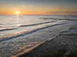 Waves and sun on horizon at Baltic Sea at sunset