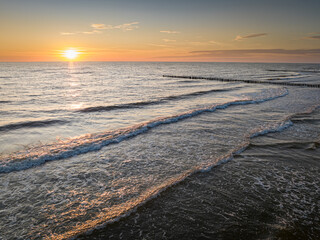 Wall Mural - Waves and sun on horizon at Baltic Sea at sunset