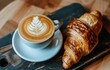 A Cup of Coffee and a Croissant on a Plate