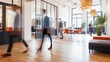 © armensl - Bright business workplace with people in walking in blurred motion in modern office space. Abstract defocused shapes of office business people. Defocused shot of business people walking in office.