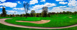 Spring landscape over the lush green fairway, sand bunkers, and swirling driveway at sunrise, a public golf course and forest in Sioux Falls, South Dakota