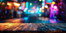 A Blurry City Street With Neon Lights And A Wooden Table In The Foreground