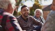 © Justlight - A man sitting with a group of elderly community members listening and chatting as part of a companionship and support program.