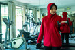 Muslim sport, Athletic Asian Muslim Sports Woman Wearing Hijab and Sportswear smiling while preparing for a workout with weights at the gym, Muslim sport concept.
