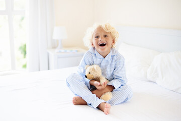 Wall Mural - Kids in bed. Children in pajamas. Family bedroom.