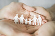 Hands holding multi generational family paper, family wellness, health insurance concept
