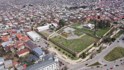 Wall Mural - Scenic view from drone of central areas of Telavi city overlooking medieval walled Batonis Tsikhe fortress on spring day, Georgia