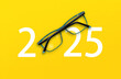 happy new year 2025. 2025 with glasses on yellow isolated background
