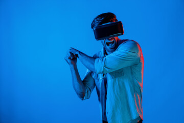 Caucasian man wearing VR glass and moving gesture holding sword. Gamer using future digital virtual reality headset or futuristic innovation to enter meta world or playing action game. Deviation.