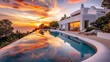 © Salman - A white villa's pool reflecting the fiery colors of sunset, with a garden that looks like a painted canvas of nature's best