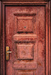 Worn apartment door with damaged handle and peephole
