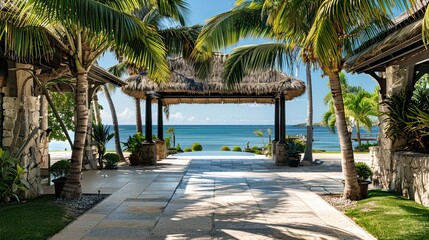 The entrance of a villa with an island feel, palm trees and a thatched-roof portico opening to the sea