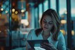 © Kishore Newton - Young professional woman using a tablet at night in a modern urban apartment, reflecting contemporary work habits.