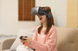 Lifestyle at home concept, LGBT lesbian women wears VR goggles and play game with joystick console