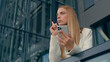 Focused serious pensive caucasian woman using mobile phone outdoors near office pondering girl businesswoman business lady think come up idea thinking about schedule write in organizer on smartphone