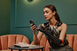 © Westend61 - Confident young businesswoman with prosthetic arm using smart phone sitting on sofa in office