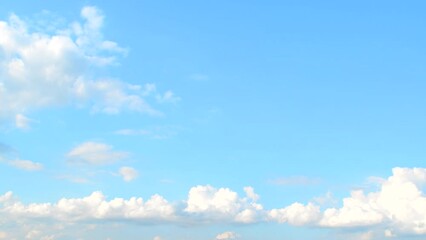 Wall Mural - White cumulus clouds slowly move in the blue summer sky. Background with some clouds and empty space for information.