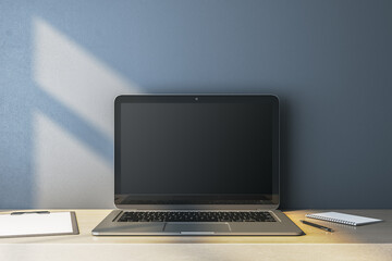 Wall Mural - close up of empty computer monitor on simple wooden desk. blue wall background. workplace concept. m