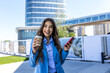 Woman texting and drinking coffee outdoors. Artificial intelligence and communication network concept. Beautiful young woman using a smartphone.