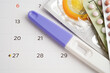 Pregnancy test with birth control pills and condom for female on calendar, ovulation day.