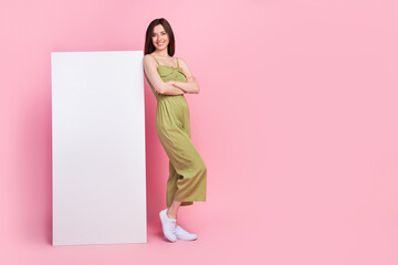 Wall Mural - Full body photo of cute positive lady wear stylish khaki outfit stand empty space offer telephone device isolated on pink color background
