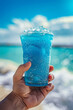 Close-up of blue raspberry slush drink in hand