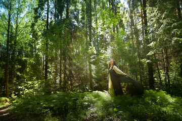 Beautiful seductive dryad. Pagan spirit of the forest. Portrait of beautiful dryad. Fairy who loves nature in beautiful green summer forest. Concept of environmental friendliness and caring for nature