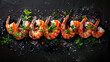 Board of tasty shrimp tails and herbs on black background