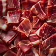 Fondo con detalle y textura de multitud de pequeñas lonchas de jamon iberico con aspecto delicioso
