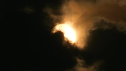 Wall Mural - Telephoto view of the sun with dramatic dark storm clouds, horror feeling