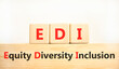 EDI equity diversity inclusion symbol. Concept words EDI equity diversity inclusion on wooden blocks. Beautiful white background. Business EDI equity diversity inclusion concept. Copy space.