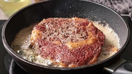 Poster - delicious juicy beef steak meat cooking on a pan with garlic and rosemary in melted butter. Process of making perfect steak at home