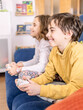 © javidestock - Children Playing Video Games on Blue Couch