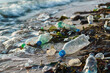 Close-up of plastic waste on the beach with waves in the background