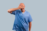 Fototapeta  - Portrait of a female physiotherapist wearing light blue dress and hands covering her face.