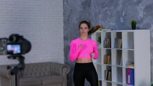 Fit Young Woman In Sportswear Running On Spot At Home While Doing Cardio Workout Training, Using Camera On Tripod To Making Video For Vlog. Fitness And Healthy Lifestyle Concept. Real Time Video.
