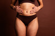 © deagreez - Cropped photo of fatty curvy lady underwear doing stomach massage isolated brown color background