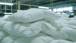 Mountain of pure white duvets in a textiles factory.