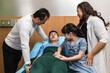 © Jack Tamrong - Father, mother and young sister visiting boy patient lying in hospital bed