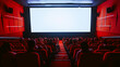 Audience sitting in a modern theater with red seats and a large blank screen ahead, giving a cinematic ambient feel.