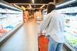 © Serhii - Young customer woman wear casual clothes shopping at supermaket store grocery shop buying with trolley cart choose products inside hypermarket.