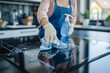 woman wearing white gloves cleaning an electric stove