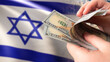 Money near Israeli flag. Dollars in hands. Concept financial assistance for Israel. Investing in Tel Aviv economy. Human is counting dollars. Funding for Israel. Economic support package for Israel